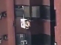 パンツ姿でエアコンの室外機にしがみつく男